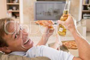 Man Enjoying Beer And Pizza In Front Of TV