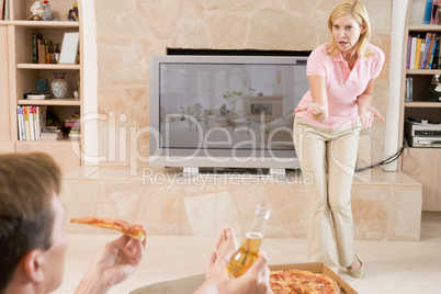 Wife Telling Husband Off For Drinking Beer And Eating Pizza