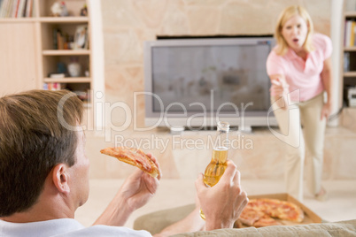 Wife Telling Husband Off For Drinking Beer And Eating Pizza