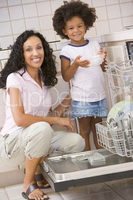 Mother And Daughter Loading Dishwasher