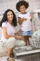 Mother And Daughter Loading Dishwasher