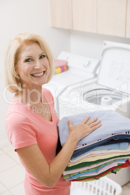 Woman Carrying Folded Up Laundry