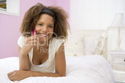 Teenage Girl Lying On Bed Using Cellphone