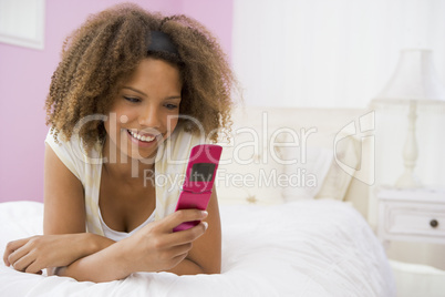 Teenage Girl Lying On Bed Using Cellphone