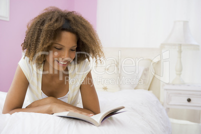 Teenage Girl Lying On Bed Reading