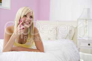 Teenage Girl Lying On Bed Using Mobile Phone