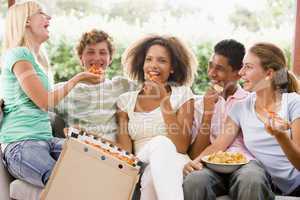 Group Of Teenagers Sitting On A Couch Eating Pizza