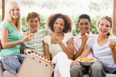 Group Of Teenagers Sitting On A Couch Eating Pizza