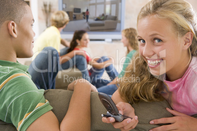 Teenagers Hanging Out In Front Of Television Using Mobile Phones