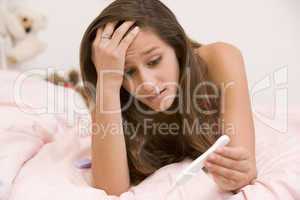 Teenage Girl Lying On Her Bed With A Pregnancy Test