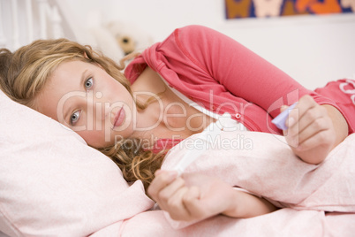 Teenage Girl Lying On Her Bed With A Pregnancy Test