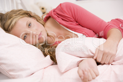 Teenage Girl Lying On Her Bed Looking Sick