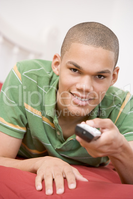 Teenage Boy Lying  On Bed Using Remote