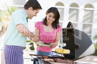 Couple Cooking On A Barbeque