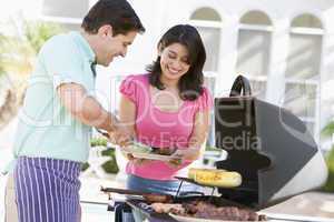 Couple Cooking On A Barbeque