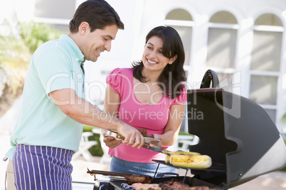 Couple Cooking On A Barbeque