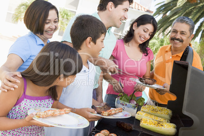 Family Enjoying A Barbeque