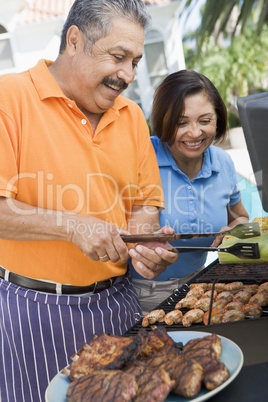 Couple Cooking On A Barbeque