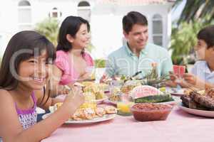 Family Enjoying A Barbeque