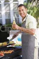 Man Barbequing In A Garden