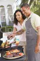 Couple Cooking On A Barbeque