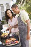 Couple Cooking On A Barbeque