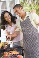 Couple Cooking On A Barbeque