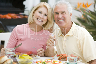 Couple Enjoying A Barbequed Meal In The Garden