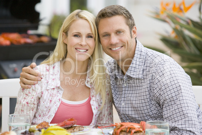 Couple Enjoying A Barbequed Meal In The Garden