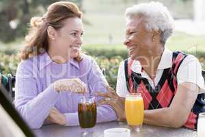 Two Female Friends Enjoying A Beverage By A Golf Course