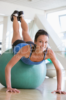 Woman Doing Push Ups On Swiss Ball At Gym