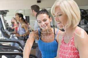 Personal Trainer Showing Woman How To Use Treadmill