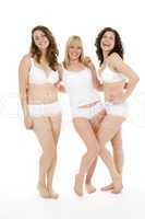 Drei junge Frauen posieren in weißer Unterwäsche