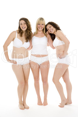 Drei junge Frauen posieren in weißer Unterwäsche.