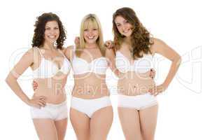 Drei junge Frauen posieren in weißer Unterwäsche.