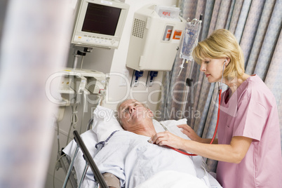 Ein älterer Patient wird von einer Ärztin mit einem Stethoskop untersucht