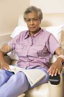 Eine ältere Frau sitzt mit einer Infusion auf einem Behandlungsstuhl