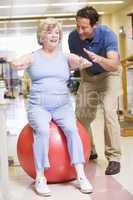 Eine ältere Frau übt mit einem Gymnastikball