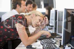 Eine Mitarbeiterin  steht  erschöpft vor ihrem Computerbildschirm