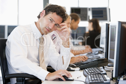 Ein junger Angestellter sitzt nachdenklich vor seinem Computer