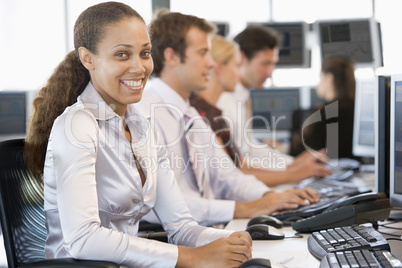 Junge Frau sitzt mit 3 Arbeitskollegen vorm PC