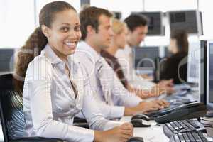 Junge Frau sitzt mit 3 Arbeitskollegen vorm PC