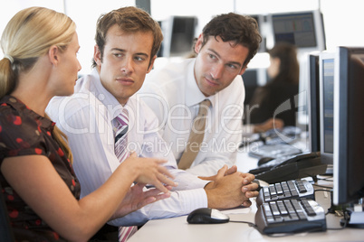 Zwei junge Männer und eine blonde Frau im Büro