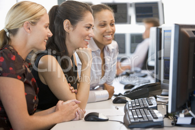 Drei junge Damen sitzen nebeneinander im Büro