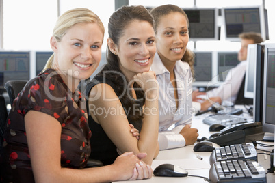 Drei junge Damen sitzen nebeneinander im Büro