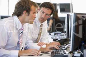 Zwei junge Männer sitzen im Büro bei der Arbeit