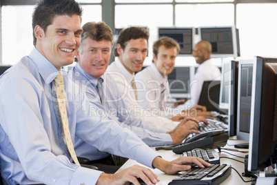 Fünf Männer nebeneinander vor Bildschirmen