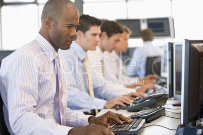 Vier junge Männer in Hemd und Krawatte im Büro