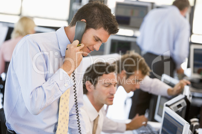 Junger Mann telefoniert in einem Großraumbüro