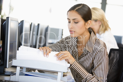 Junge Frau mit gestreifter Bluse am Schreibtisch